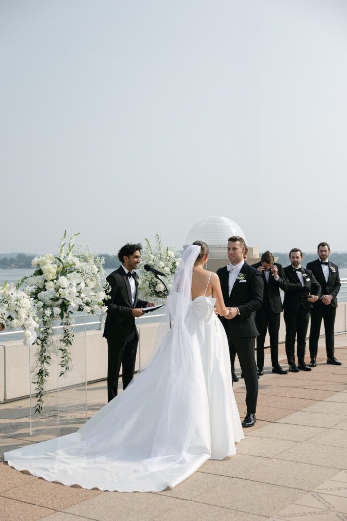 bride and groom at their ceremony at The Monona Terrace with Lake Monona in the background