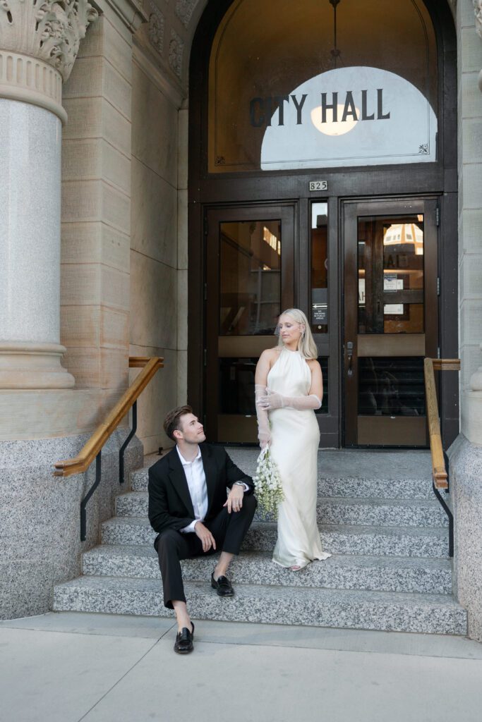 Newlyweds pose at Milwaukee City Hall, highlighting its historic architecture