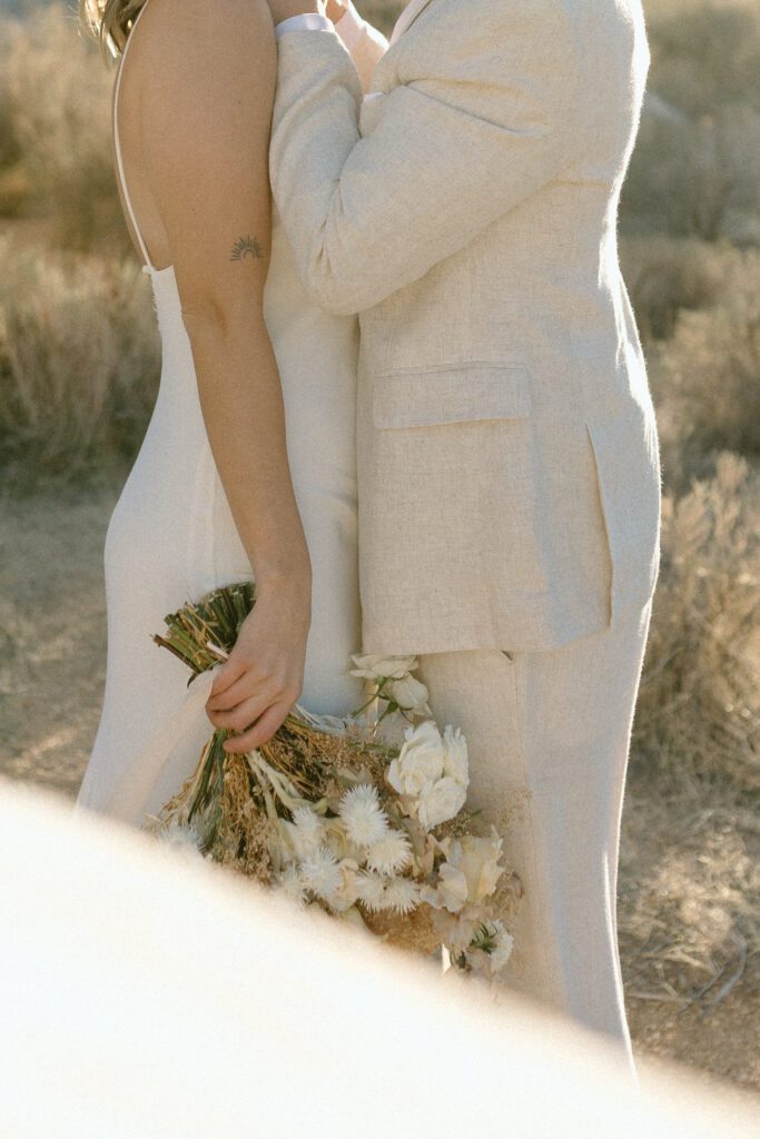 Dreamy desert elopement with bride and groom in Joshua Tree by Mariah Jones Photo wedding dress neutral florals documentary