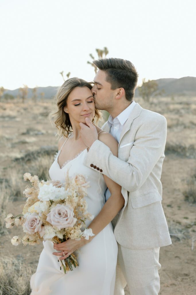 Dreamy desert elopement with bride and groom in Joshua Tree by Mariah Jones Photo wedding dress neutral florals documentary