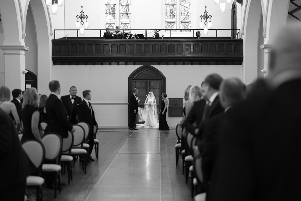 bride walking down aisle at st. james 1868 event venue