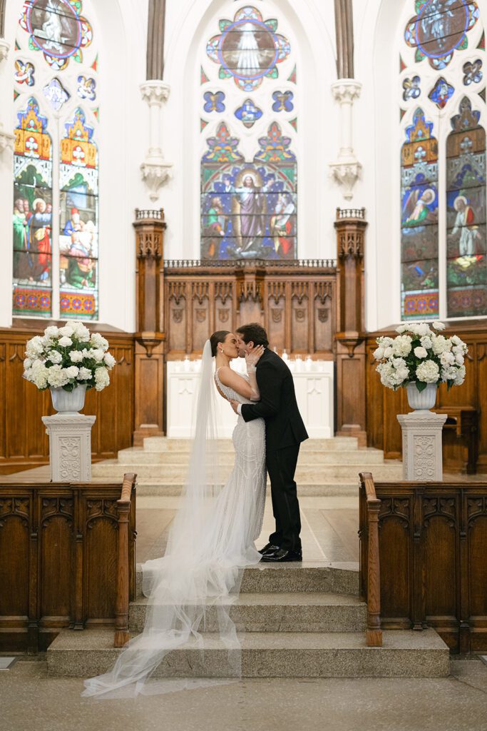 bride and groom first kiss at st. james 1868 wedding