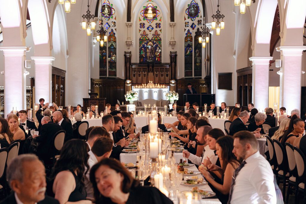 candlelit interior of st. james event center during meal at reception
