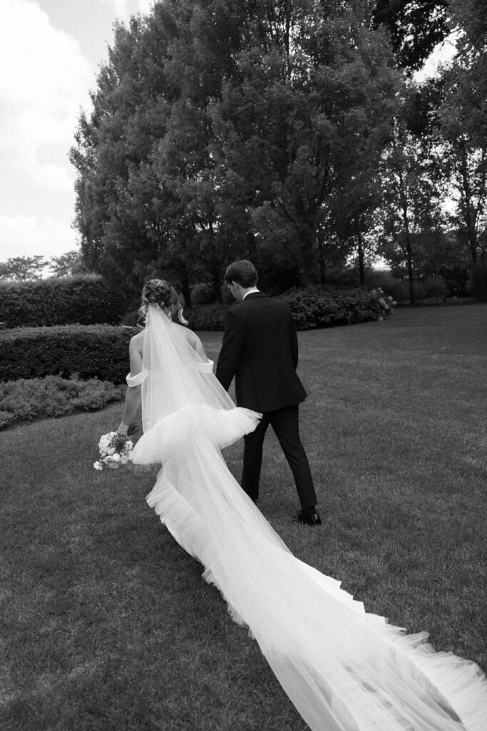 Bride and Groom walking in The Gardens on their wedding day at The Villa Terrace.