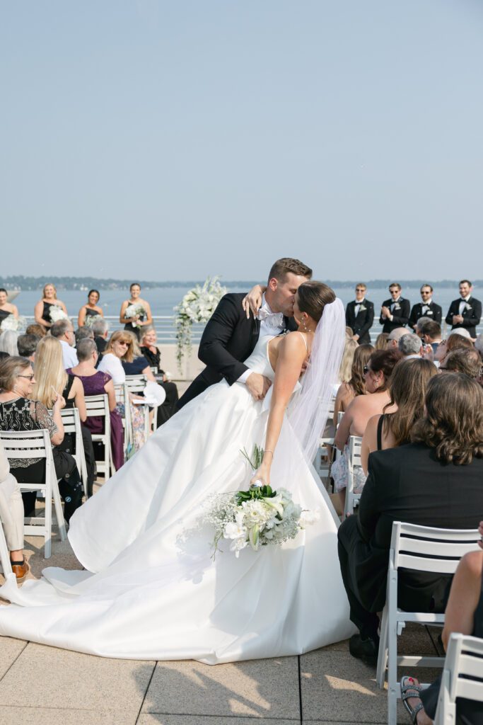 dip kiss down aisle during ceremony at the Monona Terrace with Lake Monona as the backdrop