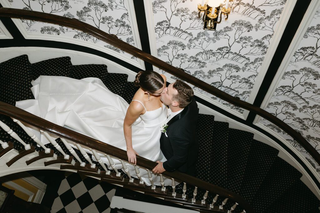 Bride and groom on The Madison Club’s elegant winding staircase in Madison, WI