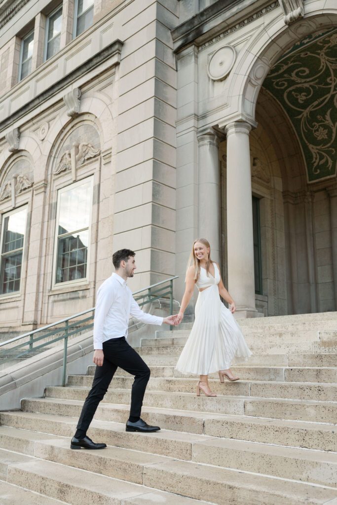 Couple walking up the steps during their engagement session at the Memorial Union in Madison.