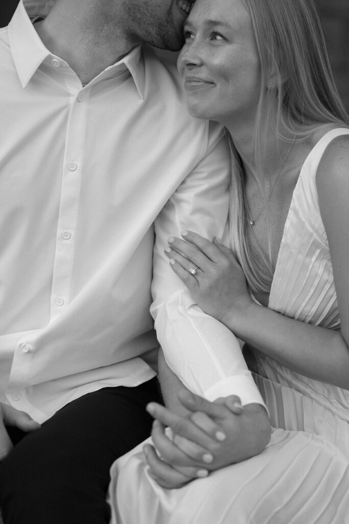 Engaged couple snuggling together on the steps at the Memorial Union.