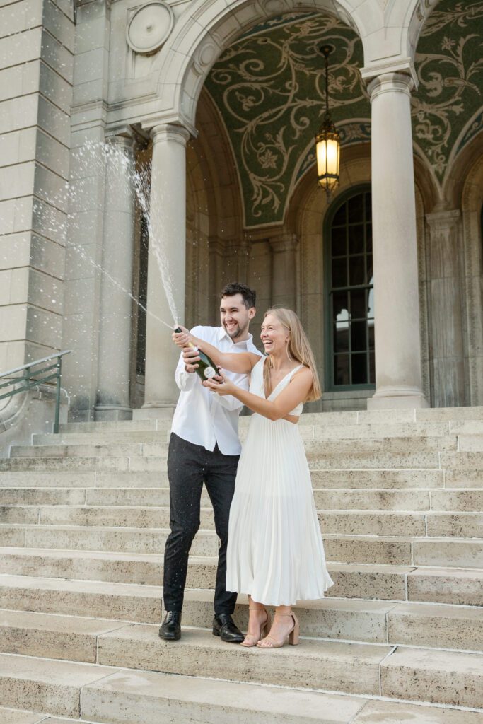 Couple popping champagne on the steps of the Memorial Union