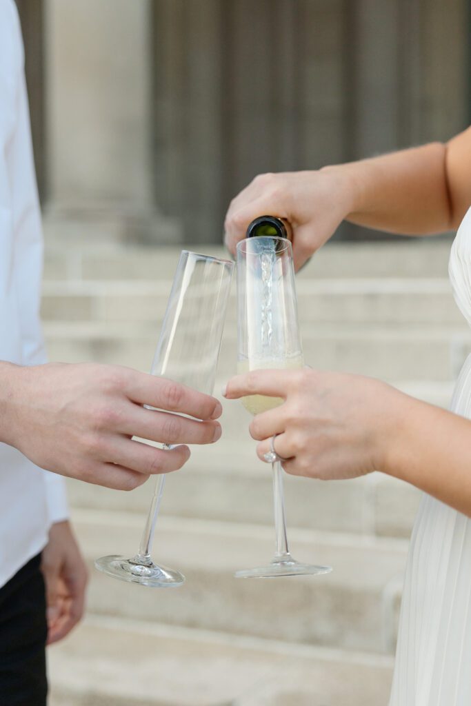 Close up of pouring champagne into glasses.