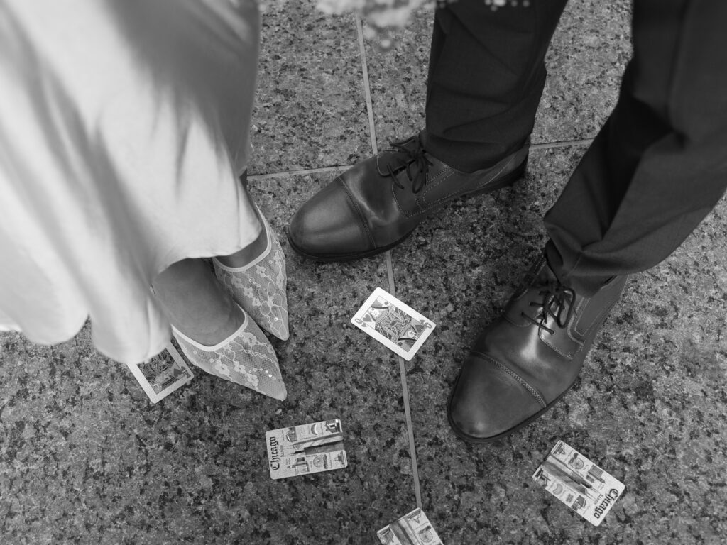 Black and white image of couple's shoes with scattered playing cards in Chicago.