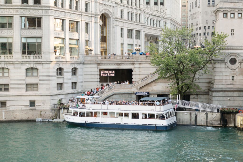 The riverwalk in Chicago featuring a boat being docked.