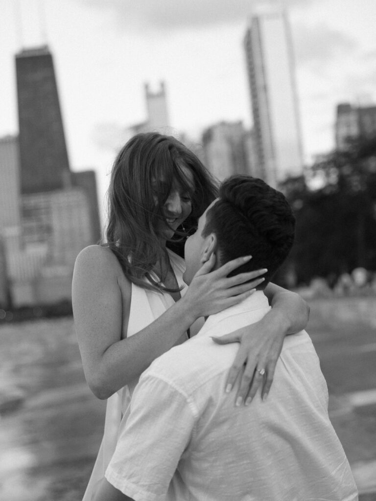 Black and white nostalgic photo of couple twirling at their engagement session in Chicago.