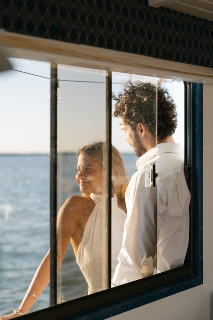 The bride and groom sharing a tender moment as they cuddle at their elopement on a boat in West Palm Beach, Florida, highlighting the intimacy of their celebration.