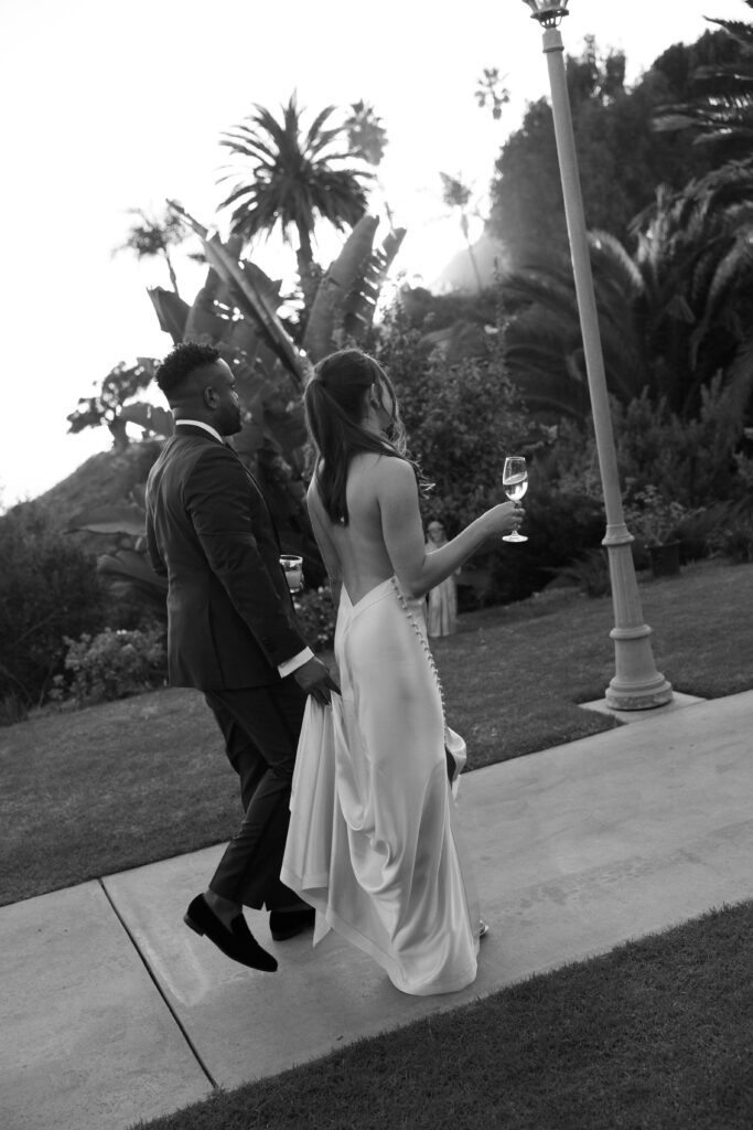 Black and white portrait of the bride and groom walking together at their Bel Air Bay Club wedding in California.