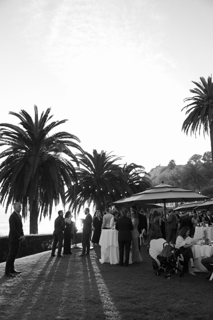 Guests mingling during cocktail hour on the lawn at a Bel Air Bay Club wedding, with ocean views and signature drinks in hand.