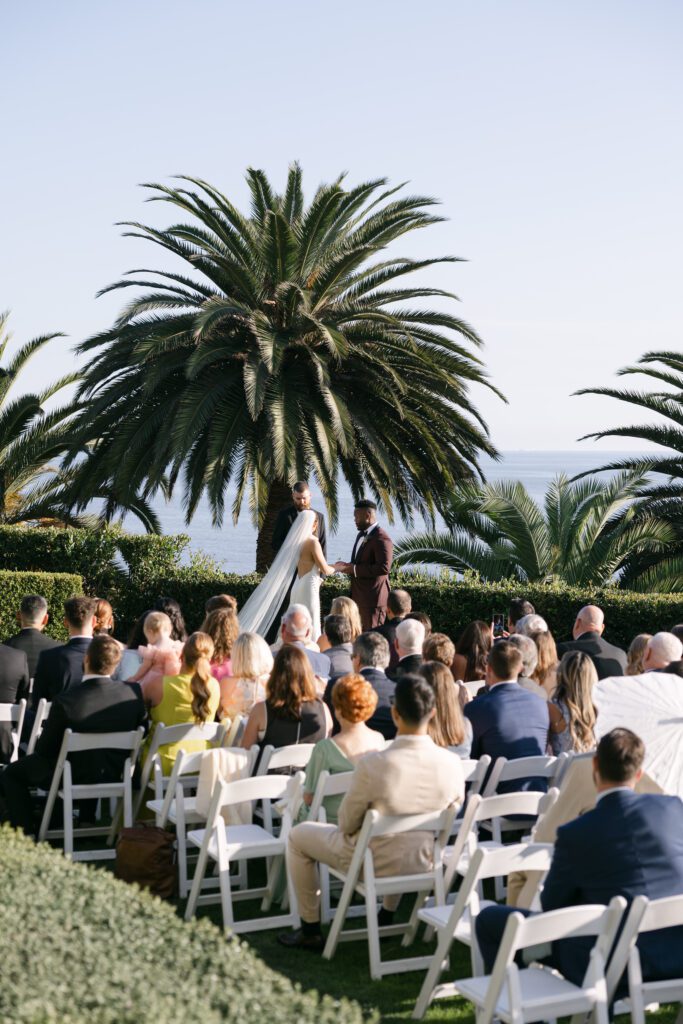 Wedding ceremony at Bel Air Bay Club with lush floral arrangements framing the oceanfront view.