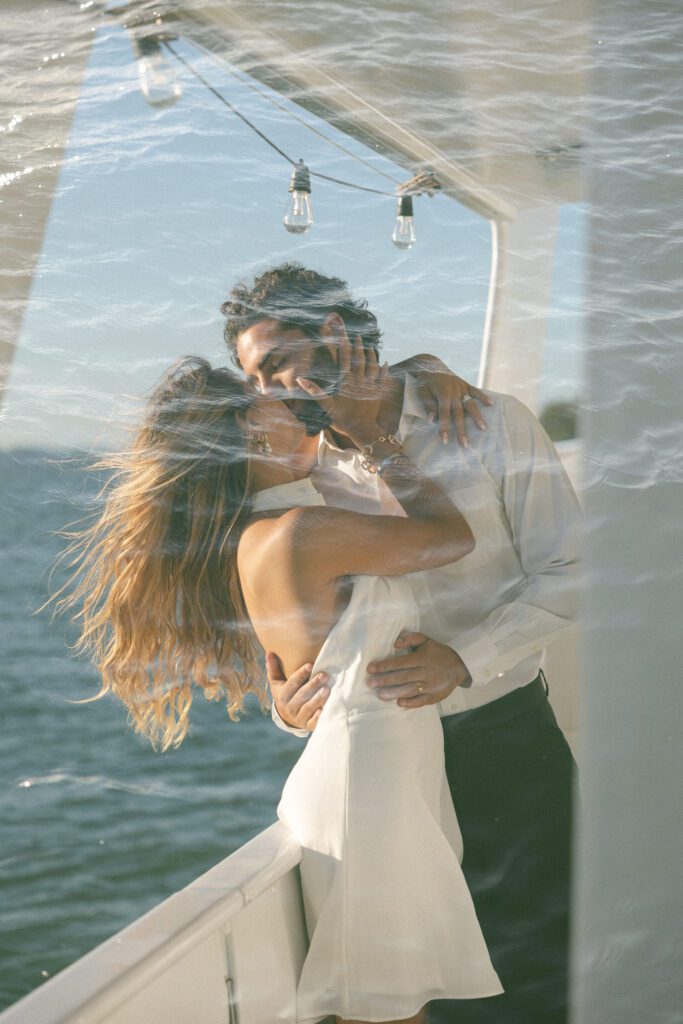 A romantic double exposure of the couple kissing on the boat, beautifully blending their love with the serene ocean backdrop during their West Palm Beach Boat Elopement.