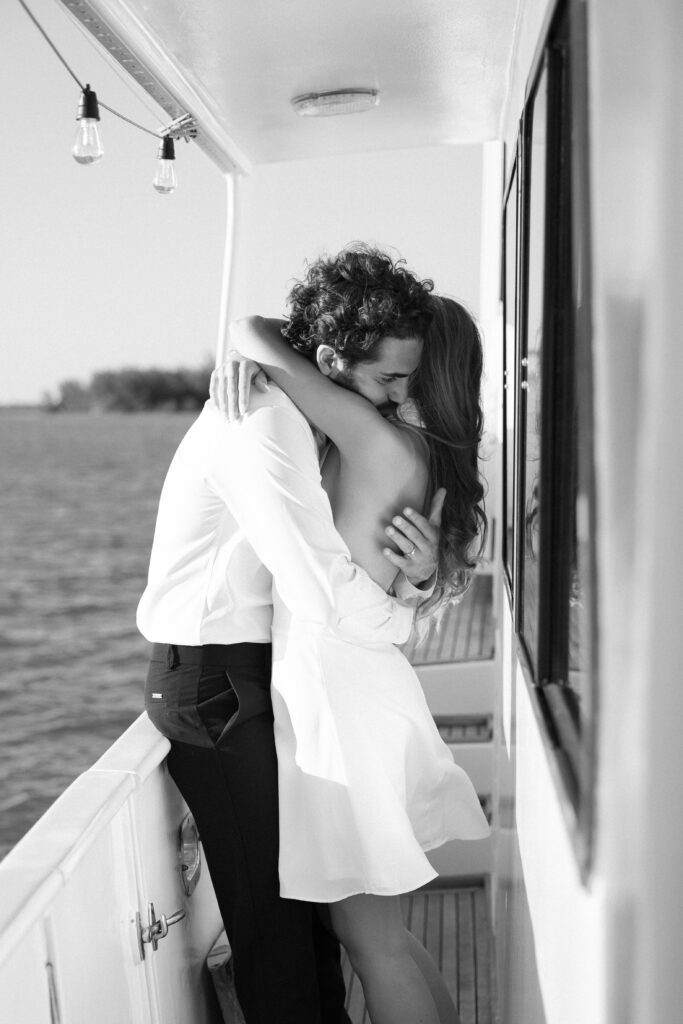 A sweet moment of the couple snuggling at their elopement on a boat in West Palm Beach, Florida, capturing the love and warmth of their special day.