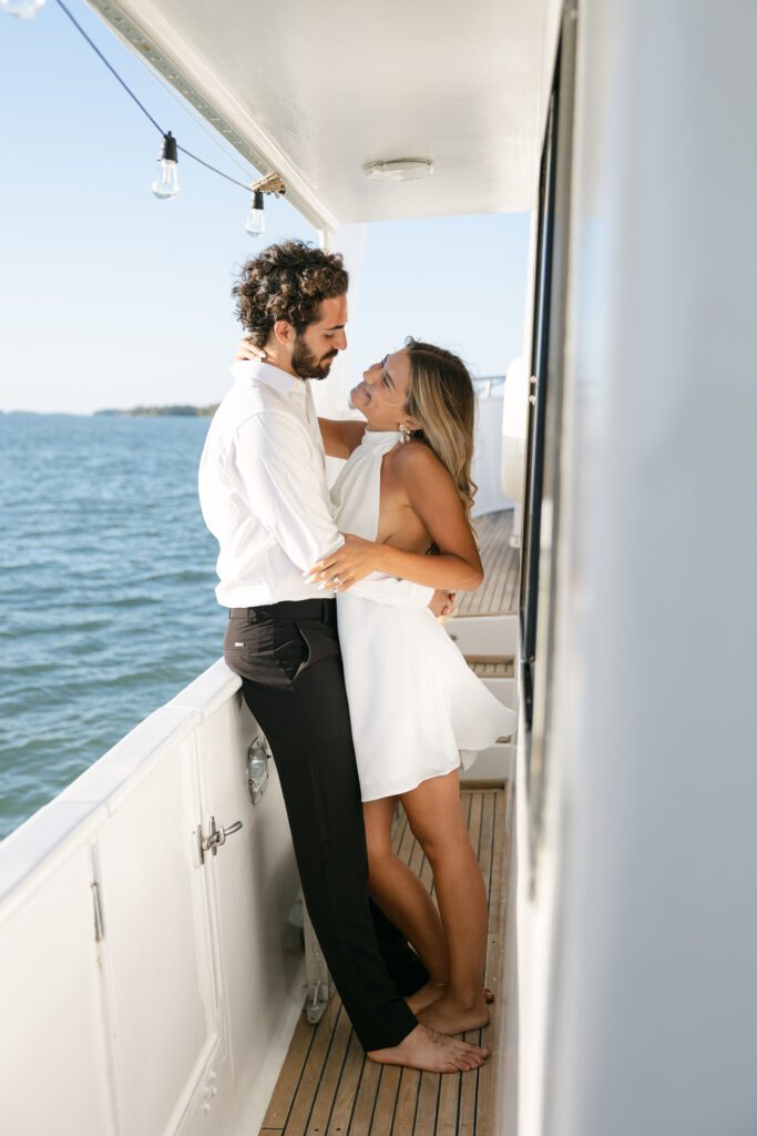 A romantic portrait of the couple cuddling together at their elopement on a boat in West Palm Beach, Florida, surrounded by the beautiful coastline.