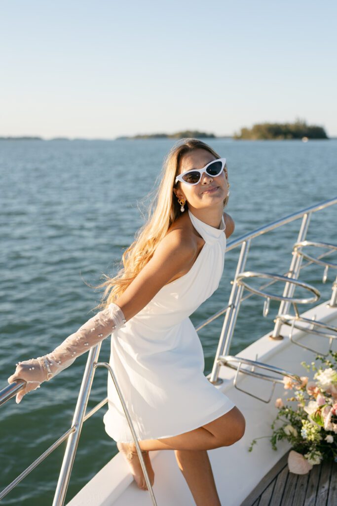 A charming solo portrait of the bride in vintage sunglasses, showcasing her radiant smile and chic style against the stunning backdrop of the West Palm Beach coastline.