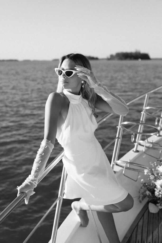 A playful portrait of the bride wearing fun vintage sunglasses, exuding confidence and style during her West Palm Beach Boat Elopement.