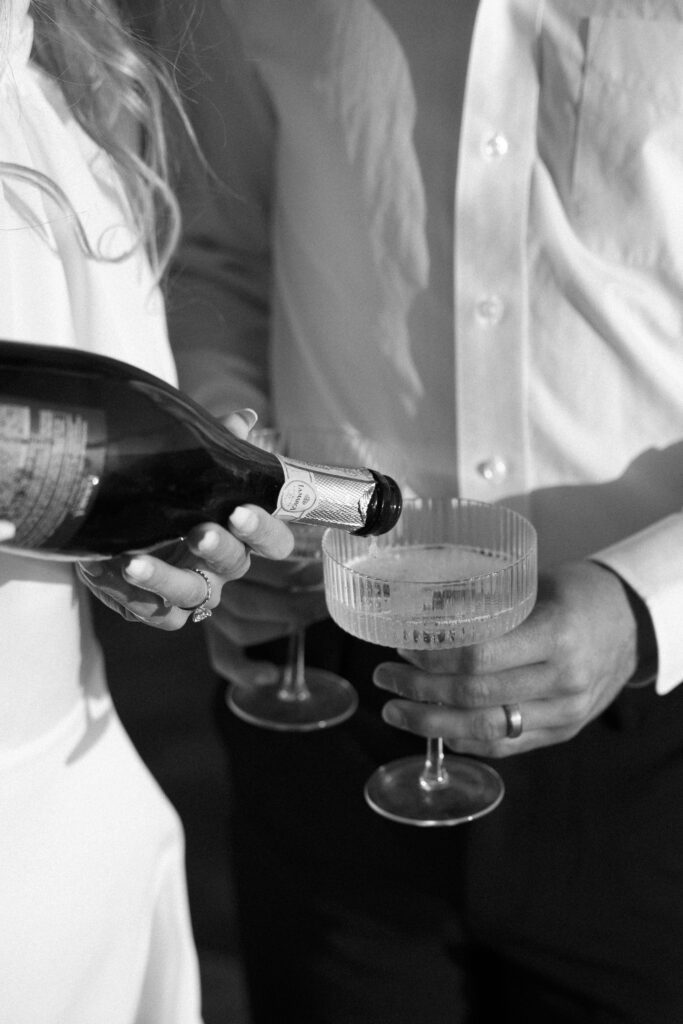 A close up of couple pouring champagne aboard their yacht to celebrate their West Palm Beach Boat Elopement.