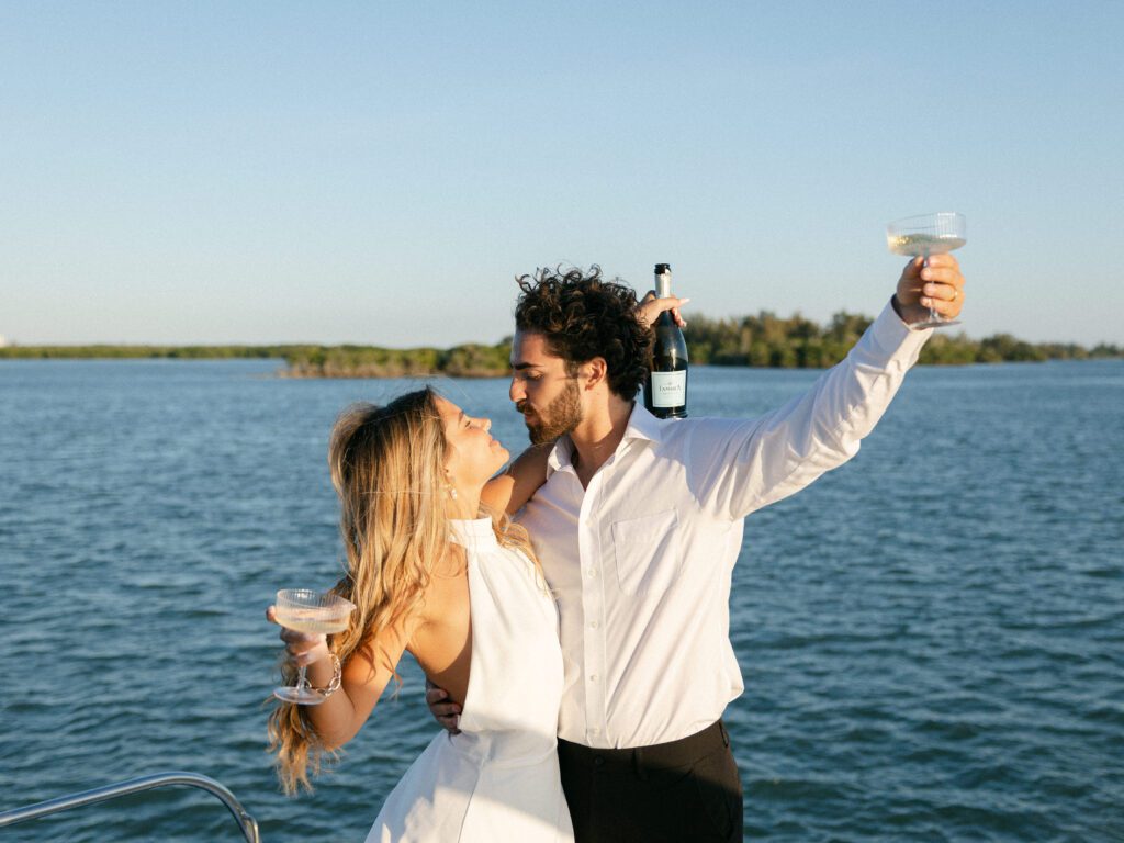 The couple joyfully popping champagne aboard their yacht to celebrate their West Palm Beach Boat Elopement.