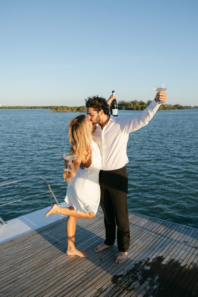 The couple laughing together as they celebrate with champagne on their West Palm Beach Boat Elopement.