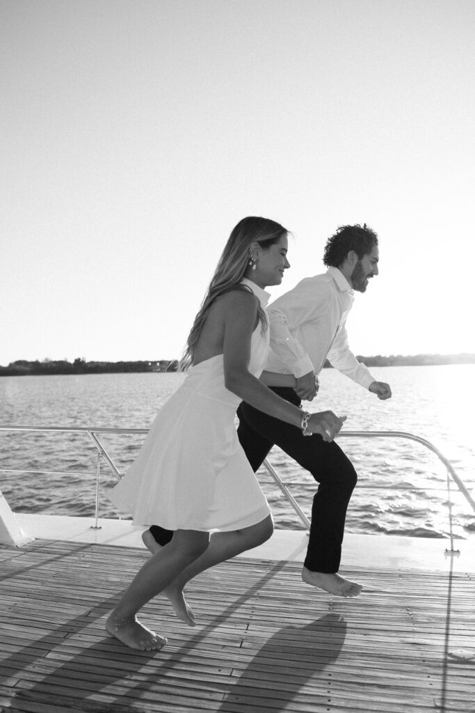 The couple joyfully jumping off the side of the yacht into the ocean, embracing the adventure of their West Palm Beach Boat Elopement.