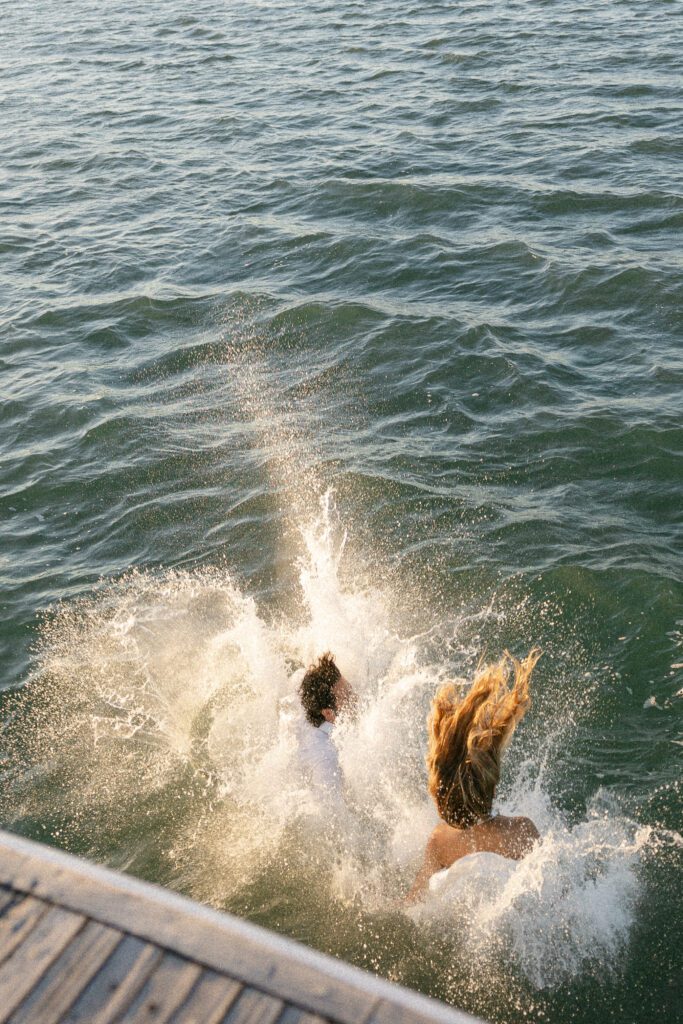 A candid shot of the couple splashing into the ocean, symbolizing their love and excitement during the West Palm Beach Boat Elopement.