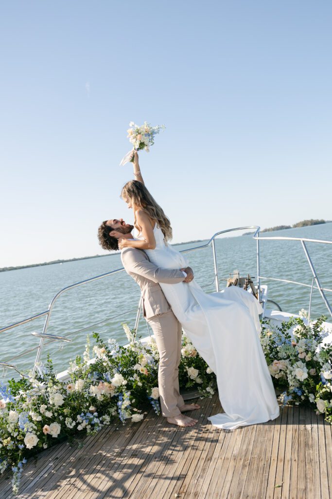 The couple dancing together on the yacht's deck, the sunset casting a warm glow around them, embodying the joy of their West Palm Beach Boat Elopement.