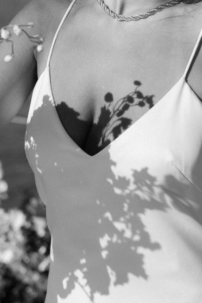 Close-up view of florals with shadows on the bride's dress, highlighting the delicate details of the bouquet during the West Palm Beach Boat Elopement.