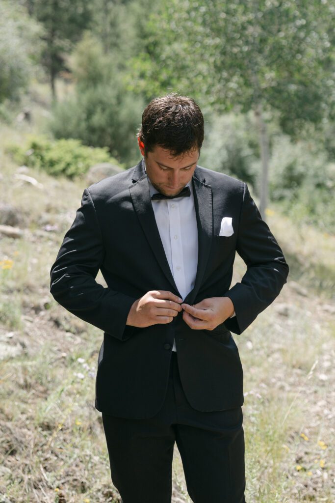 Groom buttoning jacket before Mt. Princeton Hot Springs wedding ceremony