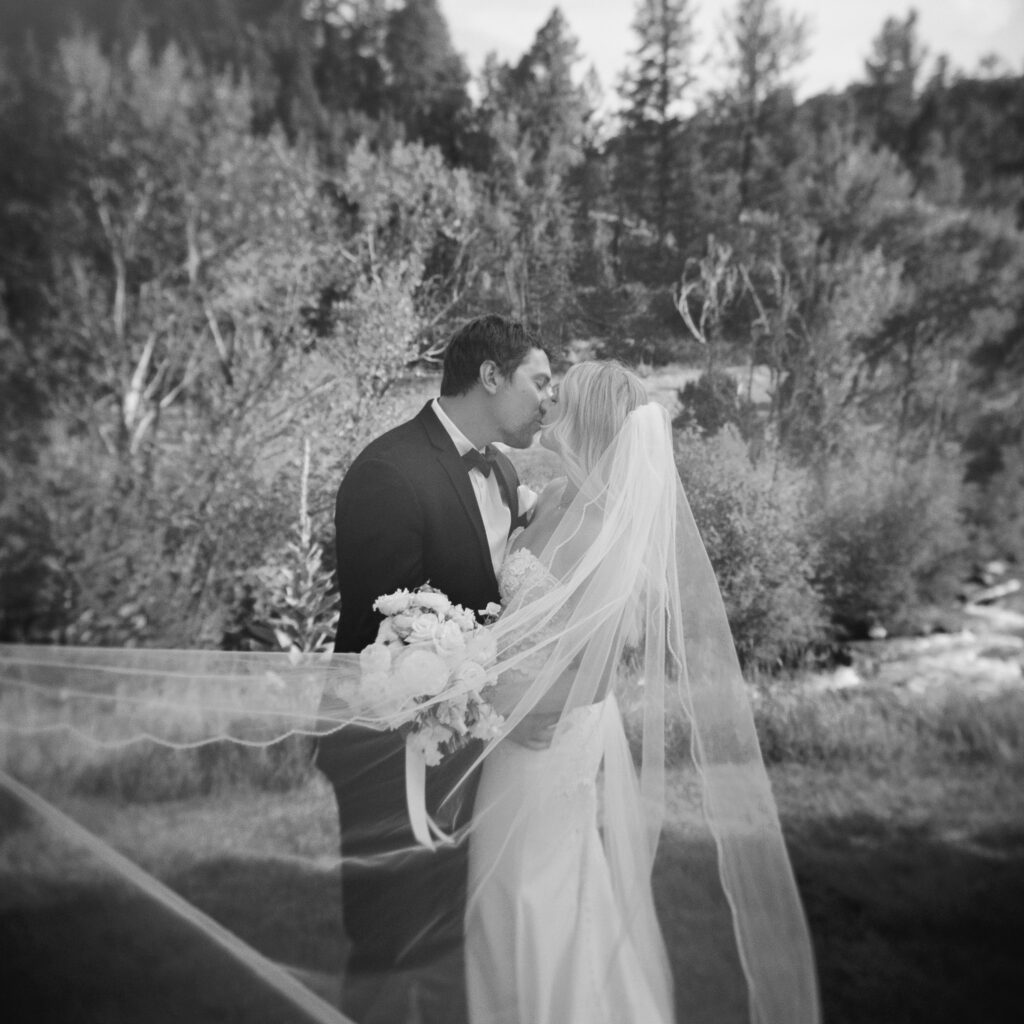Bride and groom holding hands in front of mountain backdrop at Mt. Princeton Hot Springs wedding